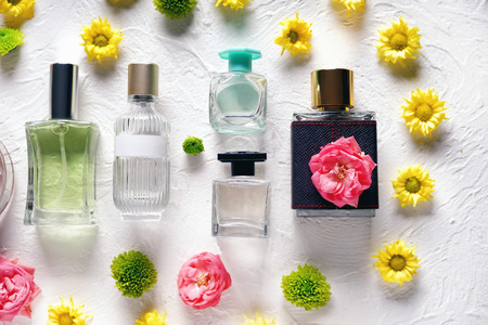 Flat lay composition with bottles of perfume and flowers on white textured backgroundの写真素材