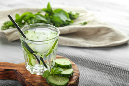 Glass of cucumber infused water on wooden boardの写真素材