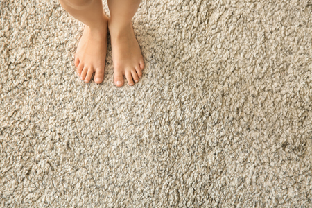 Barefoot girl standing on carpetの写真素材