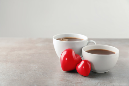 Cups of hot chocolate with red hearts on grey tableの写真素材