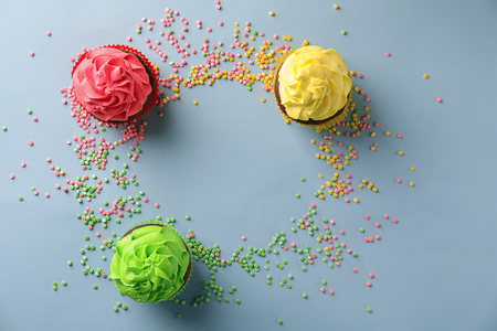 Composition with delicious colorful cupcakes on grey backgroundの写真素材