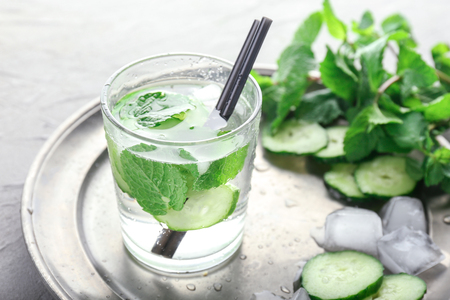 Glass of cucumber infused water with mint on tableの写真素材