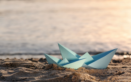 Origami boats on sea shoreの写真素材