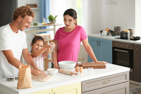 Happy family cooking together in kitchenの写真素材