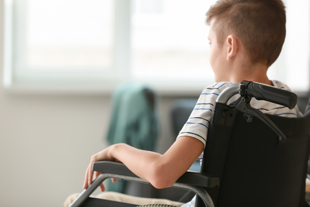 Handicapped boy in wheelchair at homeの写真素材
