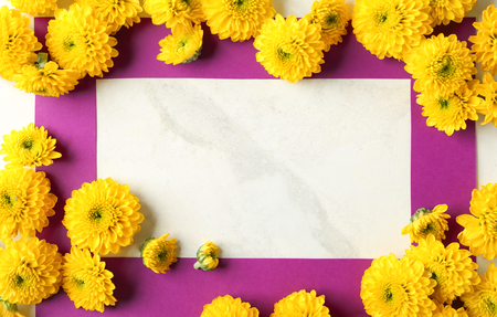 Composition with beautiful blooming flowers and paper frame on light tableの写真素材