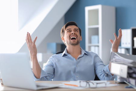 Stressed businessman at table in officeの写真素材