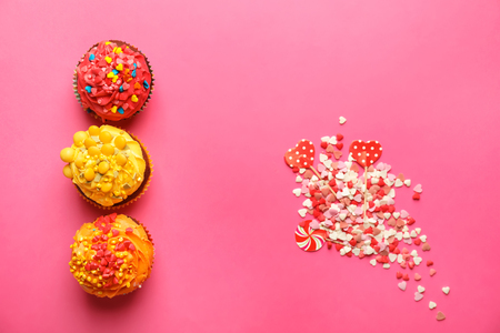 Delicious colorful cupcakes with sprinkles on color backgroundの写真素材