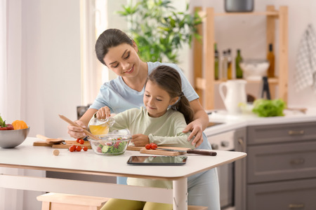 Mother and daughter cooking together in kitchenの写真素材