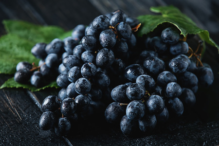 Ripe sweet grapes on dark wooden tableの写真素材