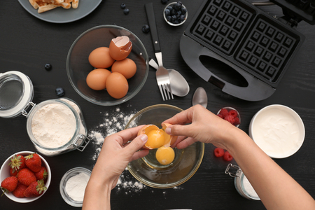 Woman making dough for waffles in kitchen, top viewの写真素材