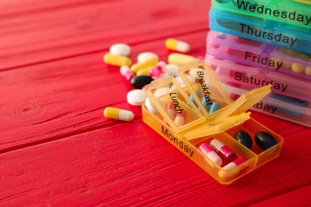Plastic containers with pills on color wooden backgroundの写真素材