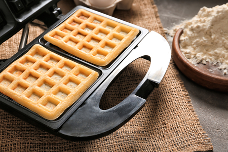 Preparing of waffles in modern maker on tableの写真素材