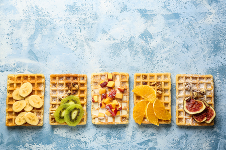 Delicious waffles with fruits on color backgroundの写真素材