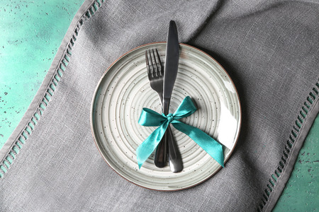Knife, fork and plate on color tableの写真素材