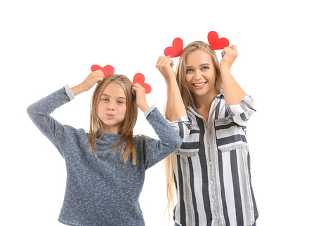 Cute little girl and her mother with red hearts on white backgroundの写真素材