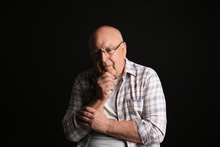 Depressed elderly man on dark backgroundの写真素材