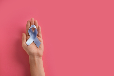 Woman holding blue ribbon on color background. Prostate cancer awareness conceptの写真素材