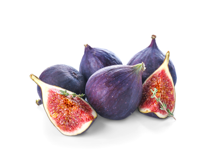 Whole and cut purple figs on white backgroundの写真素材