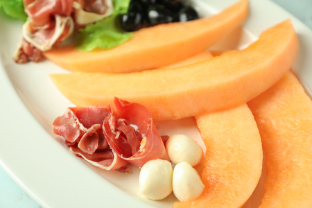 Delicious melon with prosciutto and mozzarella on plate, closeupの写真素材