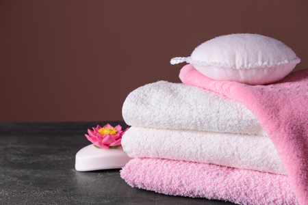 Clean soft towels, soap and wisp on grey tableの写真素材