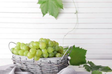 Basket with ripe juicy grapes on tableの写真素材
