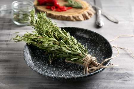 Plate with fresh rosemary on tableの写真素材