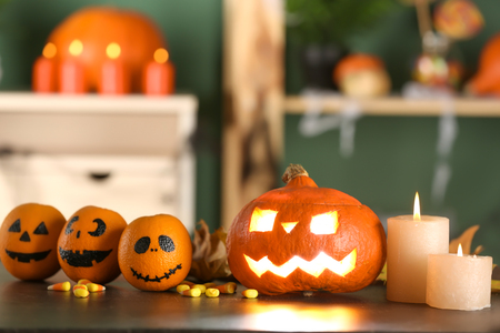 Table with burning candles and pumpkin prepared for Halloween celebrationの写真素材