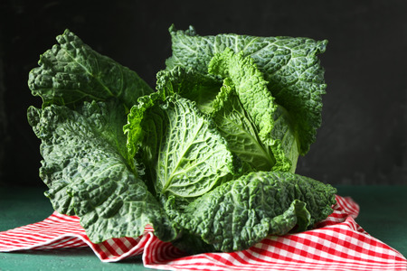 Fresh savoy cabbage on color table