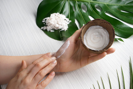 Woman applying body cream with coconut extractの写真素材