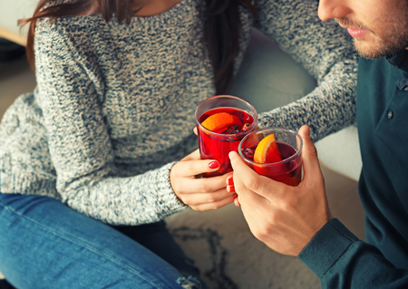 Couple drinking delicious mulled wine at home, closeupの写真素材