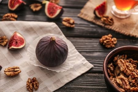 Fresh ripe figs with walnuts on wooden tableの写真素材