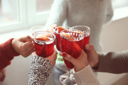 Friends drinking delicious mulled wine at partyの写真素材