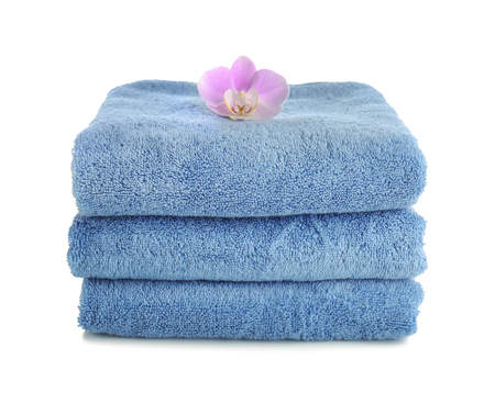 Stack of clean soft towels with flower on white backgroundの写真素材