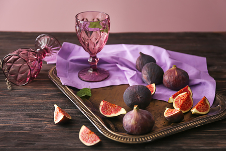 Glass of wine with fresh ripe figs on wooden tableの写真素材