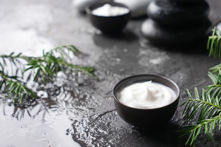 Bowl with body cream on wet dark tableの写真素材
