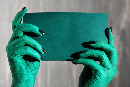 Monster holding blank card on grey backgroundの写真素材