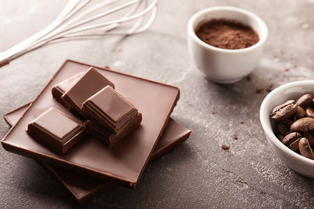 Chocolate with cacao powder and roasted coffee beans on grey tableの写真素材