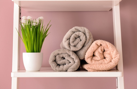 Clean towels on shelf near color wallの写真素材