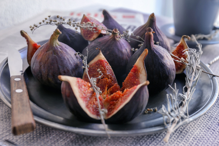 Plate with fresh ripe purple figs on table, closeup