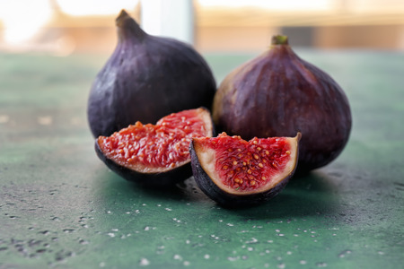 Fresh ripe purple figs on color table