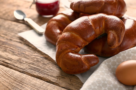 Tasty fresh crescent rolls on wooden table
