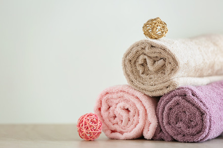 Rolled clean soft towels on light tableの写真素材