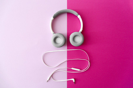 Modern headphones and earphones on color backgroundの写真素材