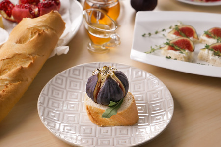 Tasty snack with ripe fig and cream cheese on plateの写真素材