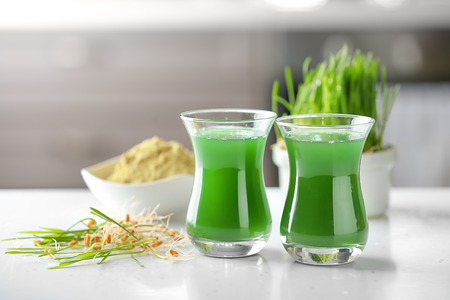 Glasses of fresh wheat grass juice on tableの写真素材
