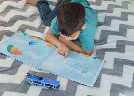 Cute little boy reading book at home