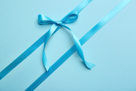 Blue ribbons with bow on color backgroundの写真素材