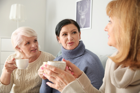 Beautiful mature women drinking coffee at homeの写真素材