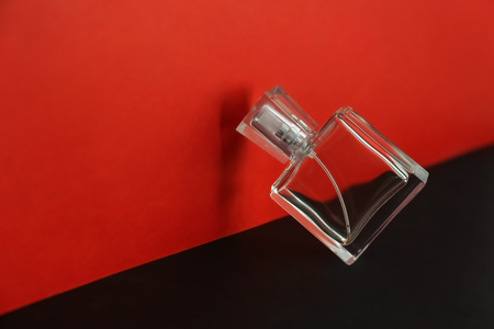Transparent bottle of perfume on color background